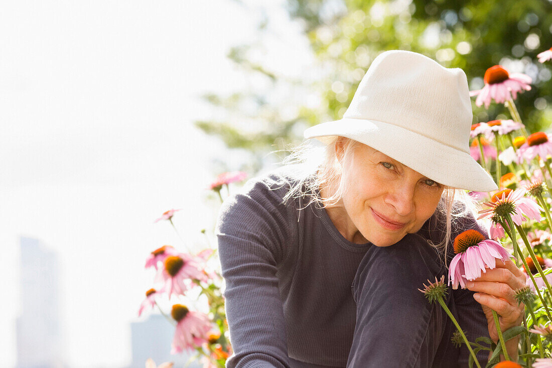 Lächelnde kaukasische Frau mit Blume