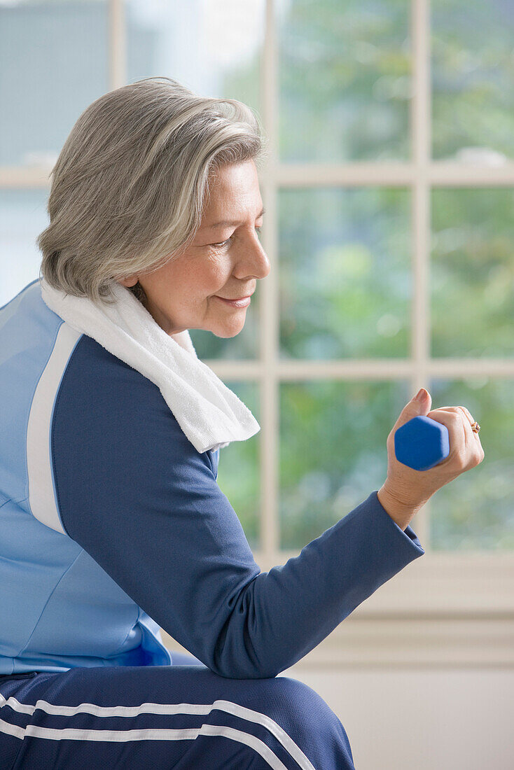 Senior Hispanic woman lifting hand weights