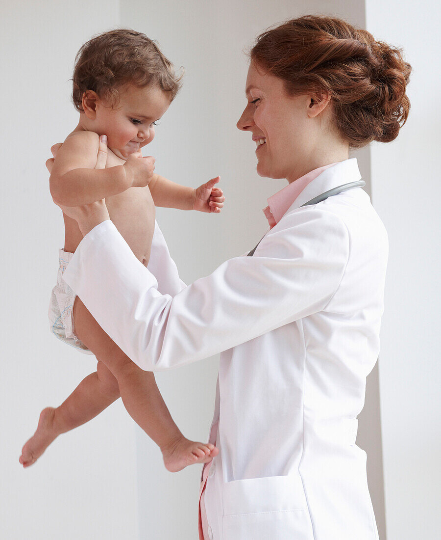Pediatrician lifting child