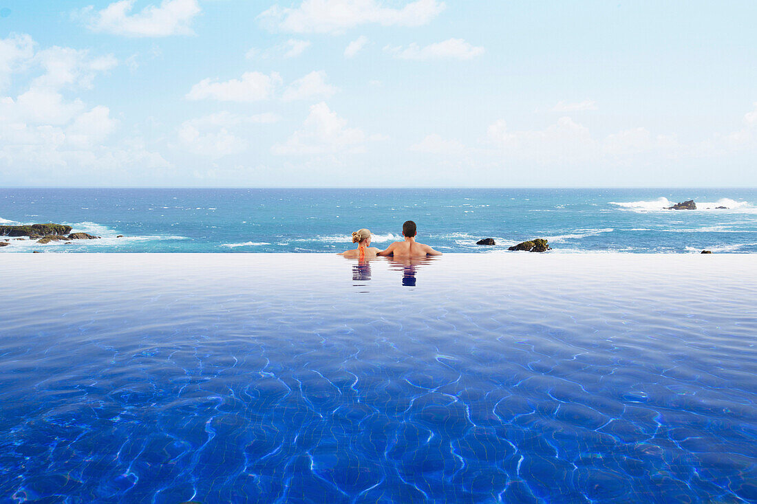 Couple relaxing in infinity pool