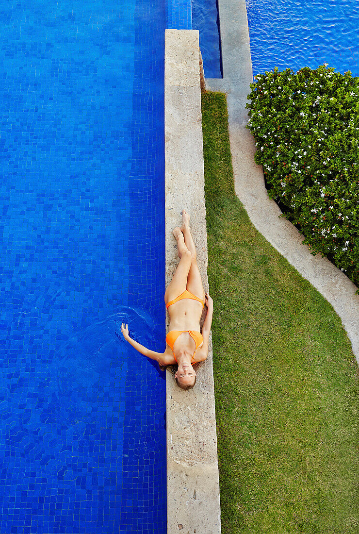 Caucasian woman relaxing by swimming pool