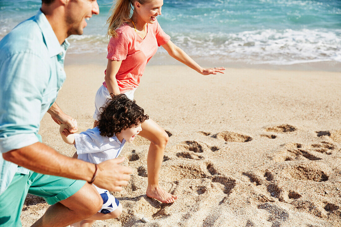 Family running together on beach