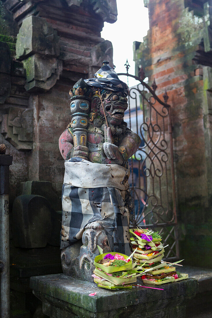 Offerings at base of Hindu statue, Ubud, Bali, Indonesia