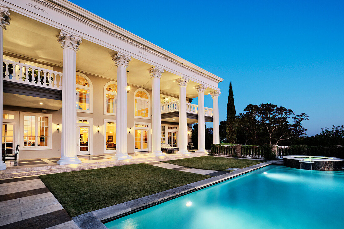 Mansion with Columns and Swimming Pool at Dusk