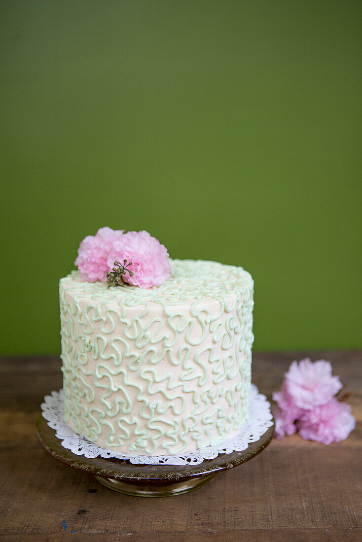 Layered Cake with Pink and White Icing and Pink Flowers