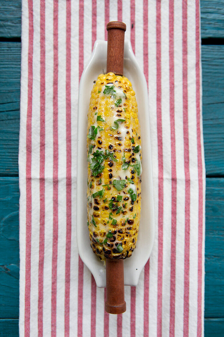 Grilled Corn with Herb Butter on Striped Towel, High Angle View