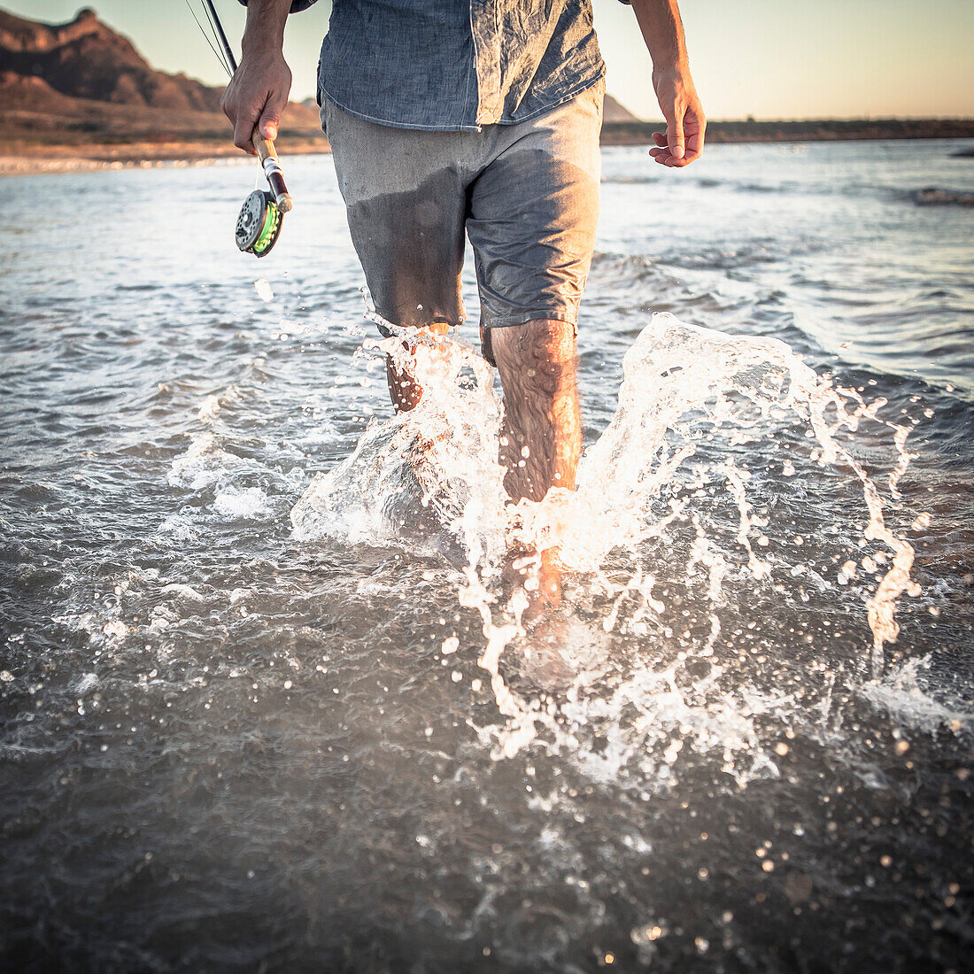 Man with Fly-fishing Pole Walking Through Shallow Water and Splashing