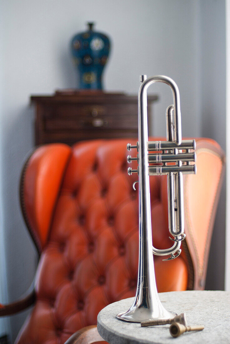 Trumpet on End table with Leather Chair in Background