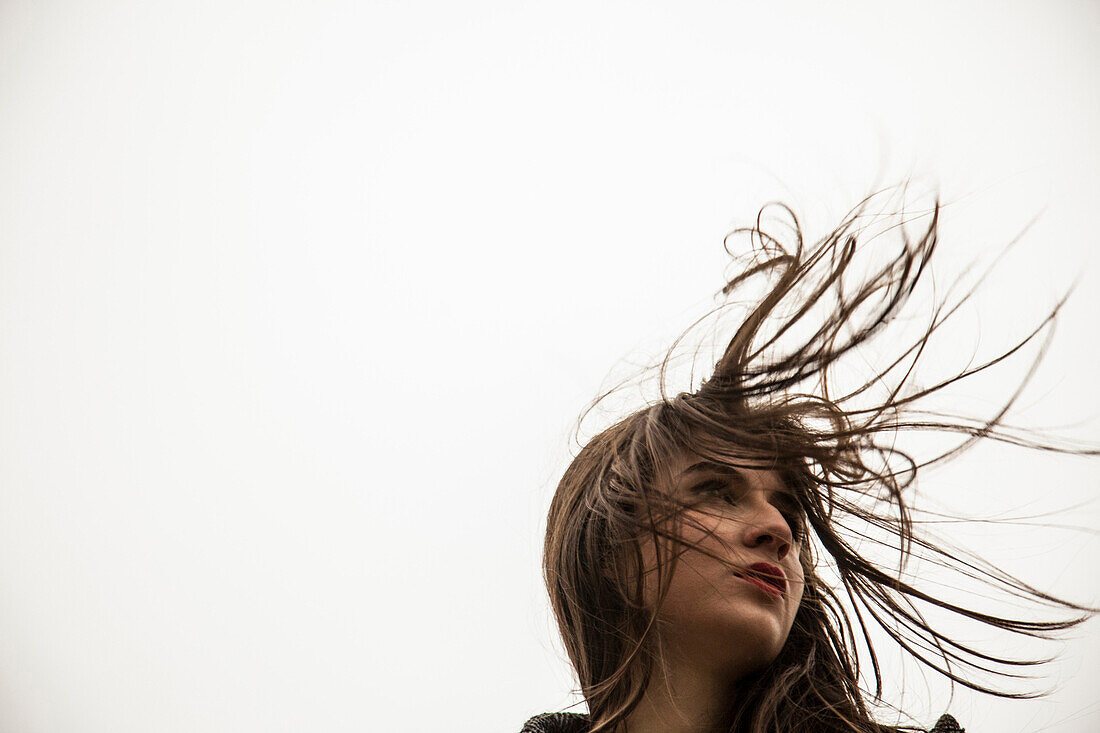 Porträt einer jungen Frau mit im Wind wehendem Haar, Tiefblick