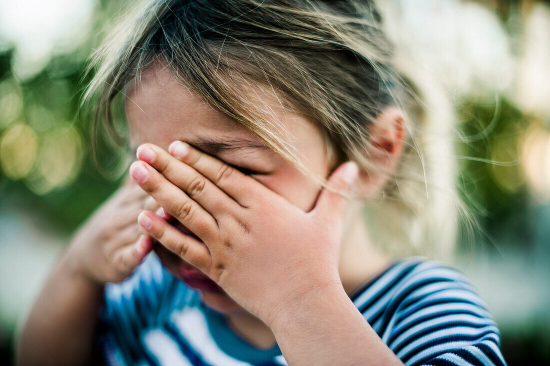 Young Girl Crying with Hands Covering Face