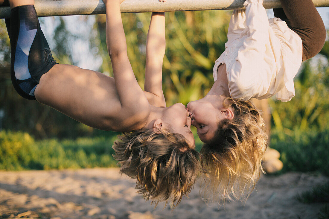 Young Boy and Girl Hanging Upside Down Kissing