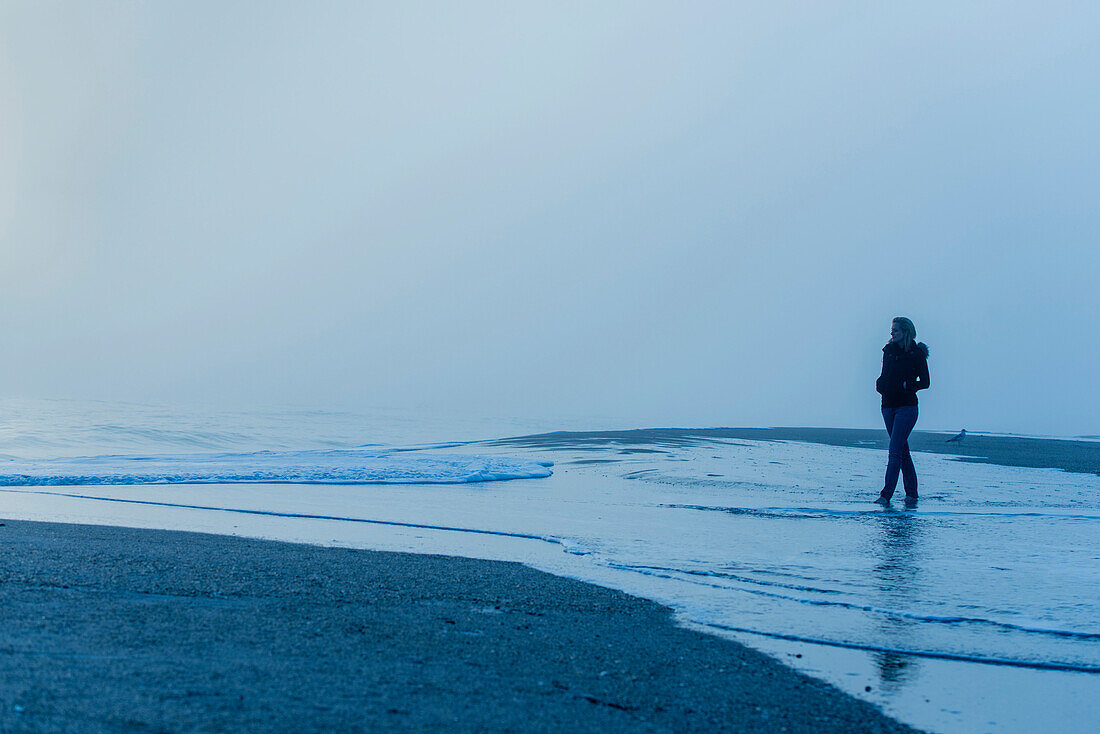 Caucasian woman walking in waves on beach, Melbourne Beach, Florida, USA