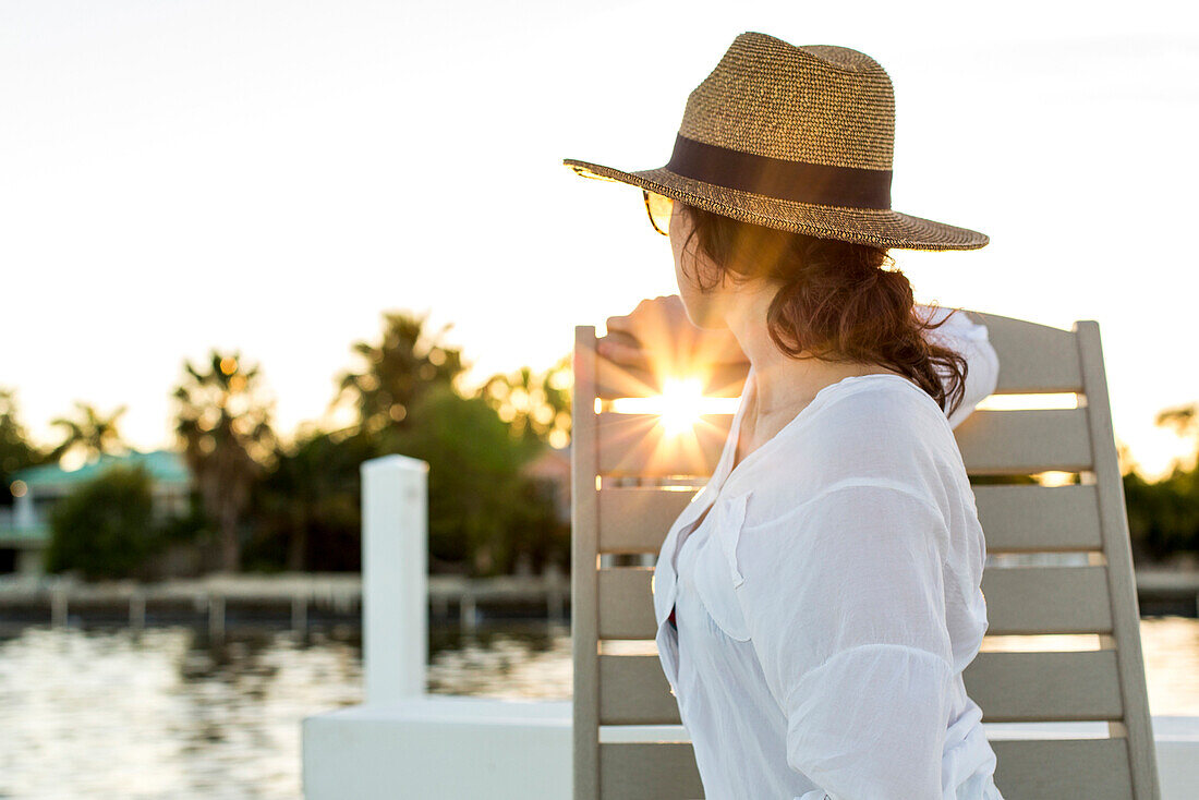 Caucasian woman admiring sunset from deck chair, Florida Keys - Big Pine Key, Florida, United States