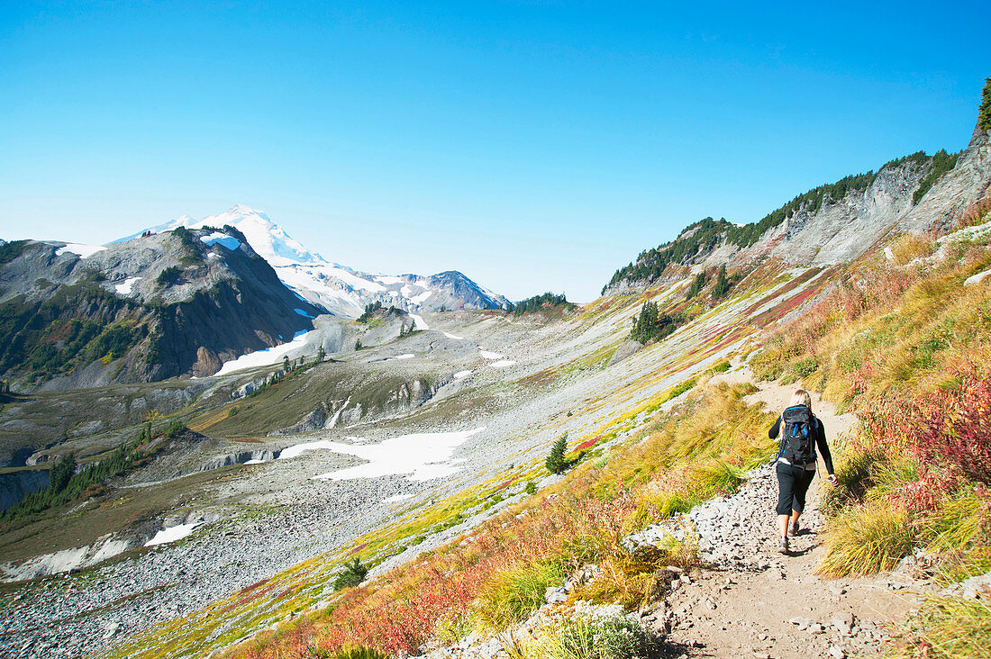 Woman hiking on rocky trail on remote hillside, glacier, washington, usa