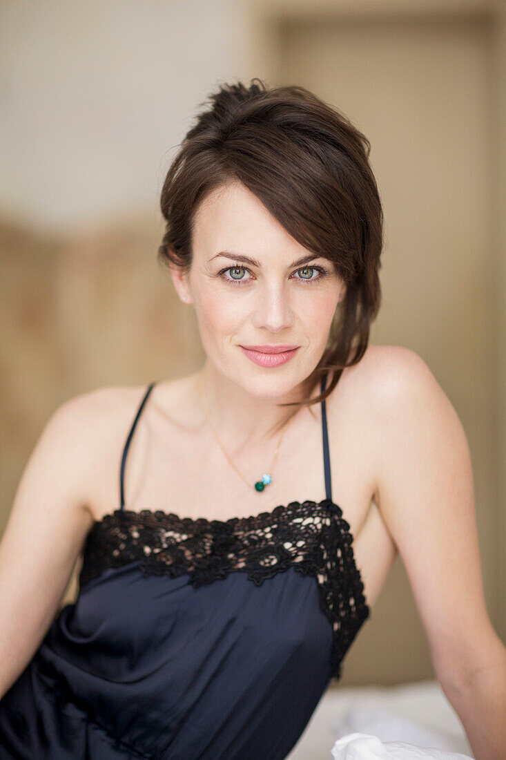 Portrait of a beautiful woman sitting on the bed