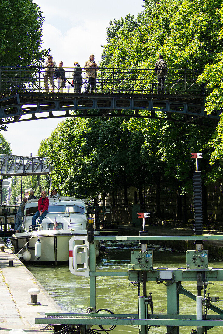 France, Paris, Canal St Martin, boat going through a dam