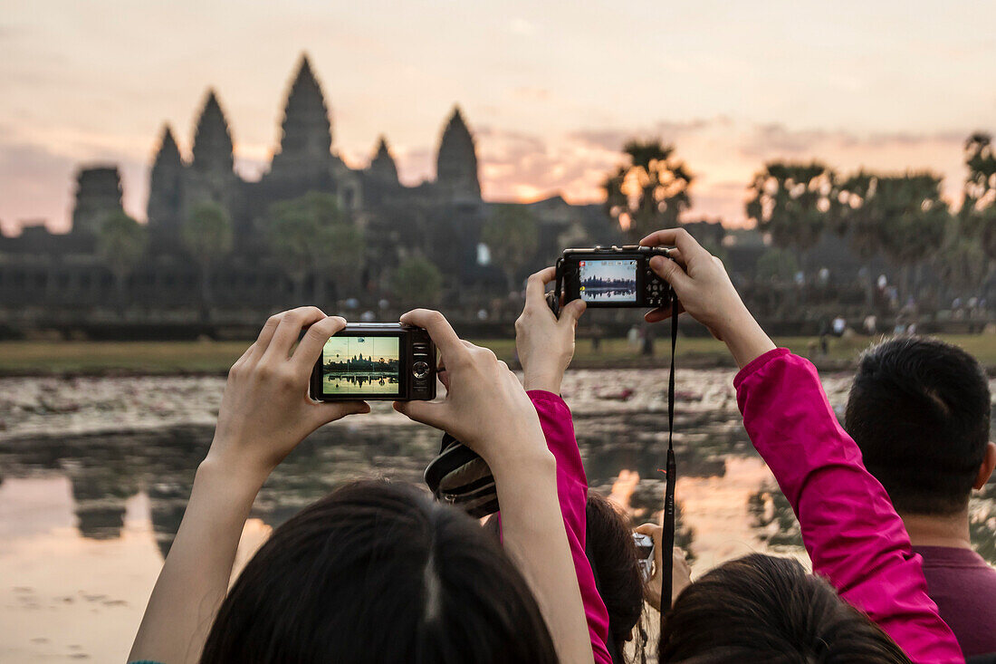 Tourists photographing the sunrise over the west entrance to Angkor Wat, Angkor, UNESCO World Heritage Site, Siem Reap, Cambodia, Indochina, Southeast Asia, Asia