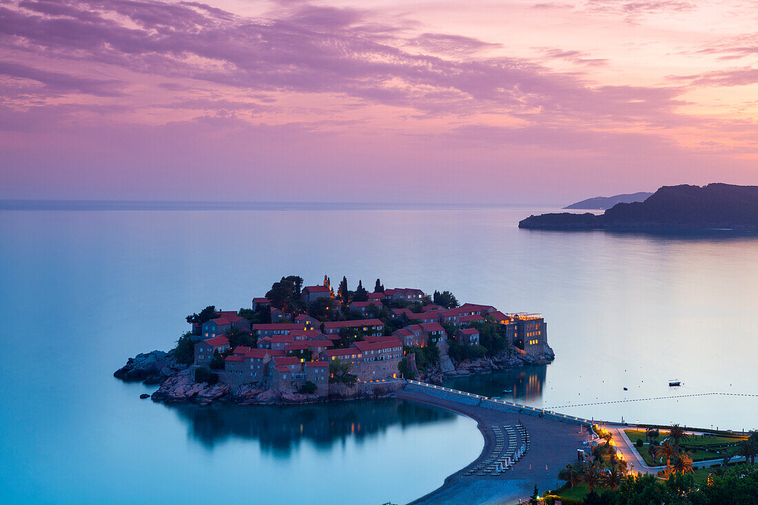 Elevated view over the picturesque island of Sveti Stephan illuminated at dusk, Sveti Stephan, Montenegro, Europe