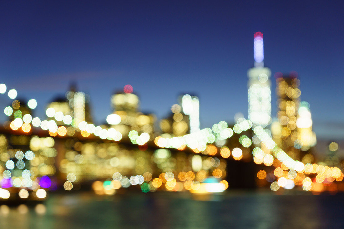 Defocussed view of Brooklyn Bridge and Lower Manhattan skyline at night, New York City, New York, United States of America, North America