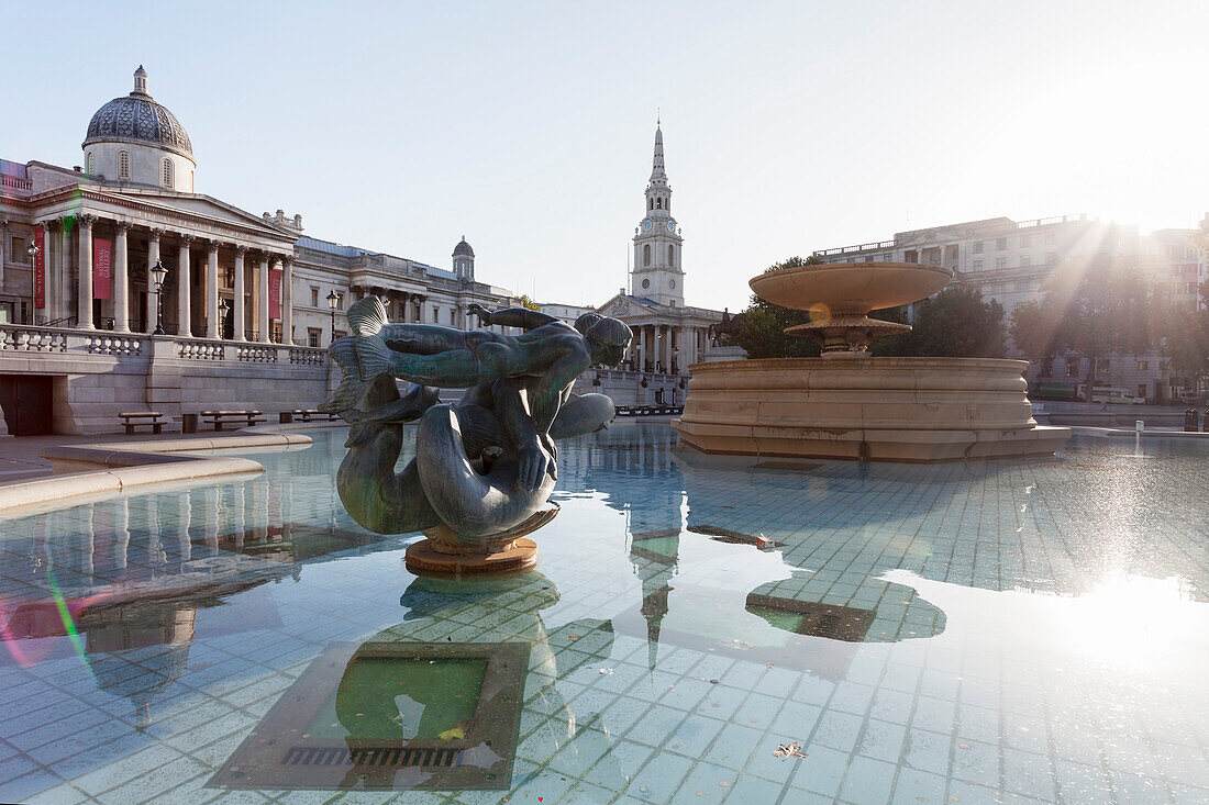 Fountain with statue, National Gallery and St. Martin-in-the-Fields church, Trafalgar Square, London, England, United Kingdom, Europe