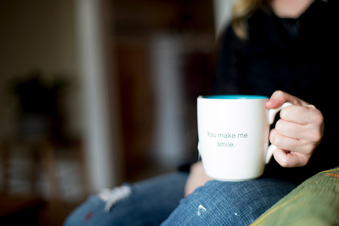 A mug wanting a smile sits on a woman's lap.