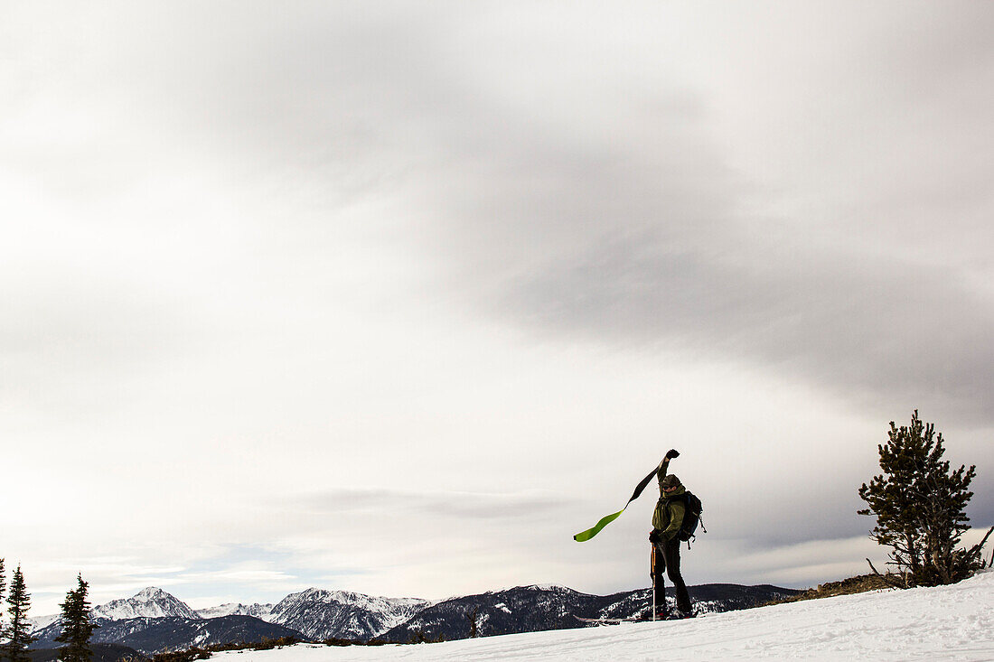 Man takes the skins off his skis in the backcountry of Montana.