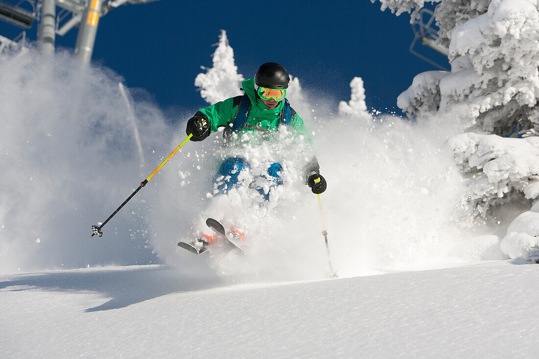A man skiing powder on a beautiful sunny day in Utah.