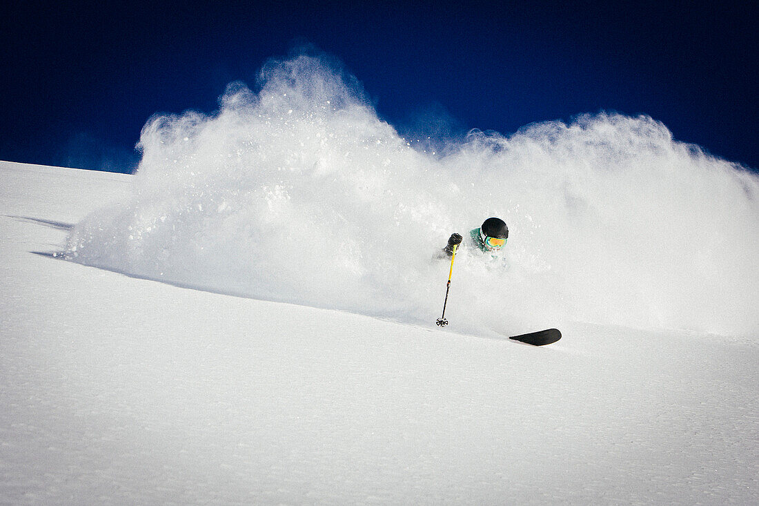 A man skiing powder on a beautiful sunny day in Utah