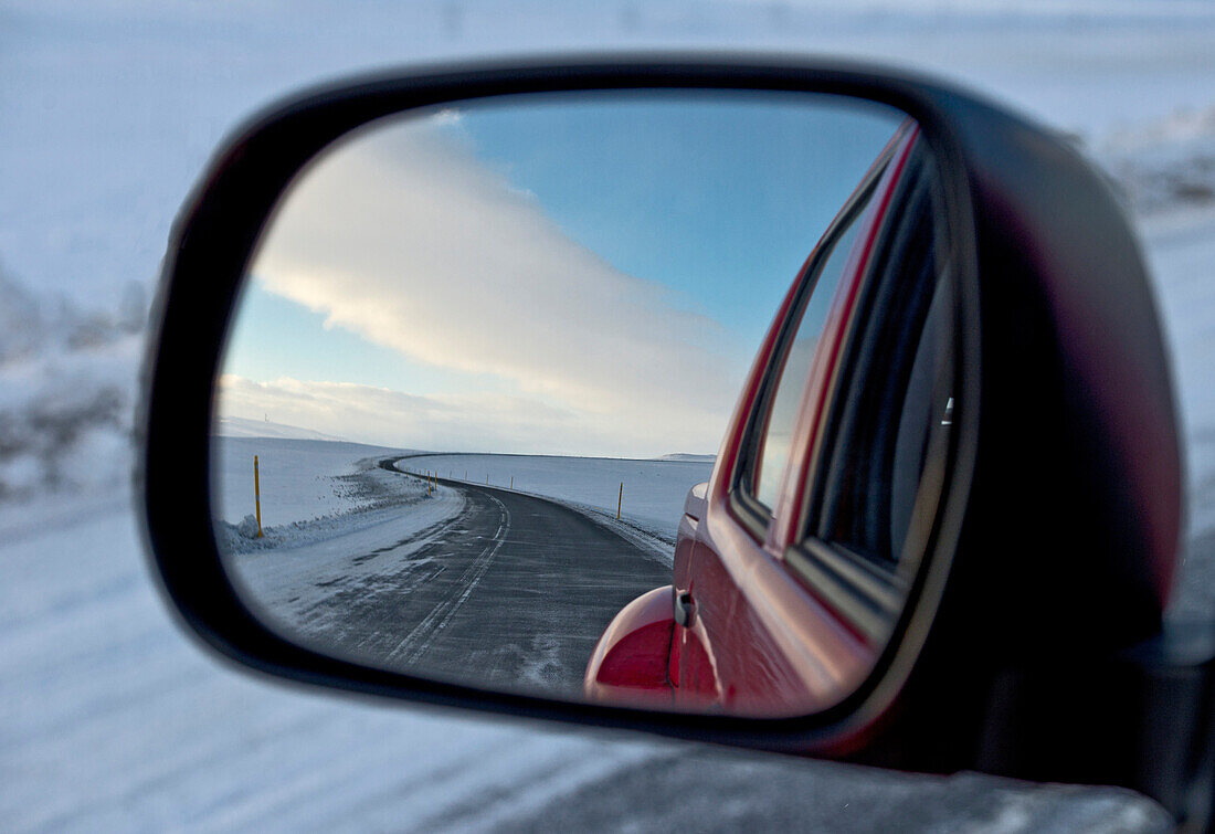 snowy road reflecting in the wing mirror of a 4x4 pick up truck