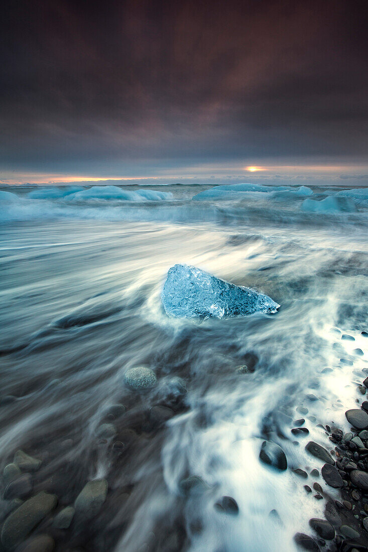 Glacial ice from Breiðamerkurjökull sits on the beach  of the coast at Breiðamerkursandur, Iceland, also known as the Jokulsarlon.