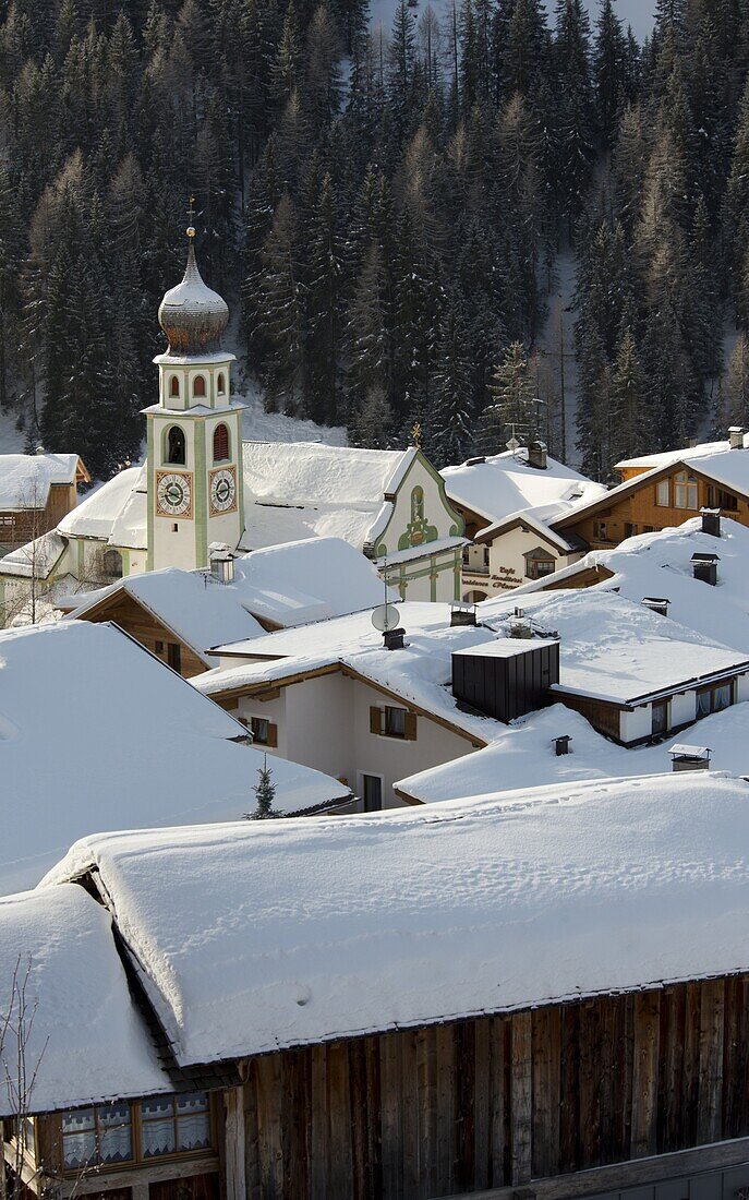 An early morning view of snow covered rooftops in San Cassiano near the Alta Badia ski area, Dolomites, South Tyrol, Italy, Europe