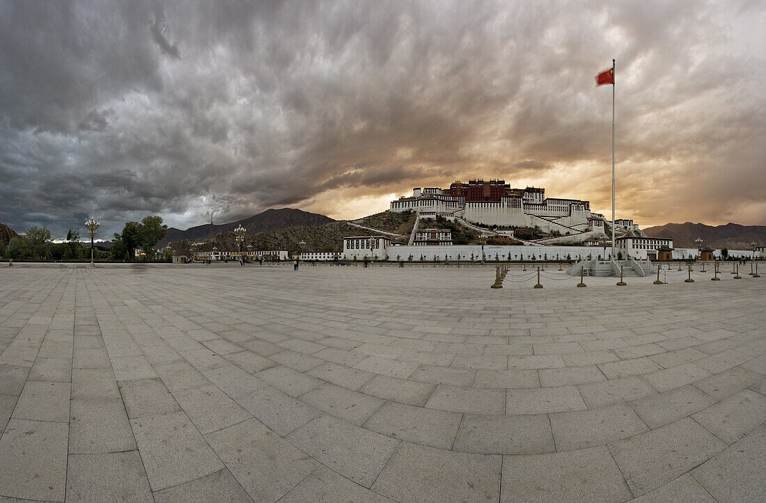 Panorama of dramatic evening sky over the Potala Palace, UNESCO World Heritage Site, and the red flag of China flutters over the Dalai Lama's former home, Lhasa, Tibet, China, Asia