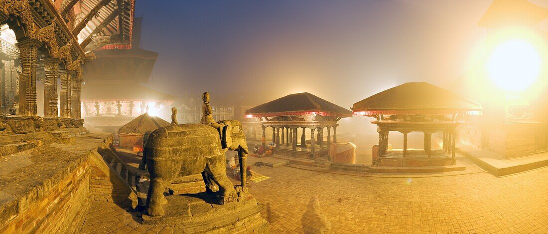 Foggy dawn in Durbar Square, containing elephant statues at the foot of the Bishwanath Mandir, and steps to drinking water tap of Manga Hiti, UNESCO World Heritage Site, Patan, Kathmandu, Nepall, Asia