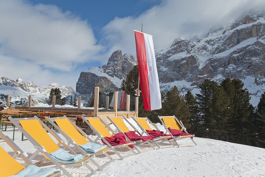 Colourful sun loungers outside a mountain restaurant, Sella Ronda ski area, Val Gardena, Sella Massif under winter snow, Dolomites, South Tirol, Trentino-Alto Adige, Italy, Europe