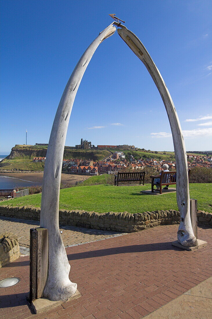Whalebone arch on Seafront, with Whitby abbey ruin in distance, Whitby, North Yorkshire, Yorkshire, England, United Kingdom, Europe