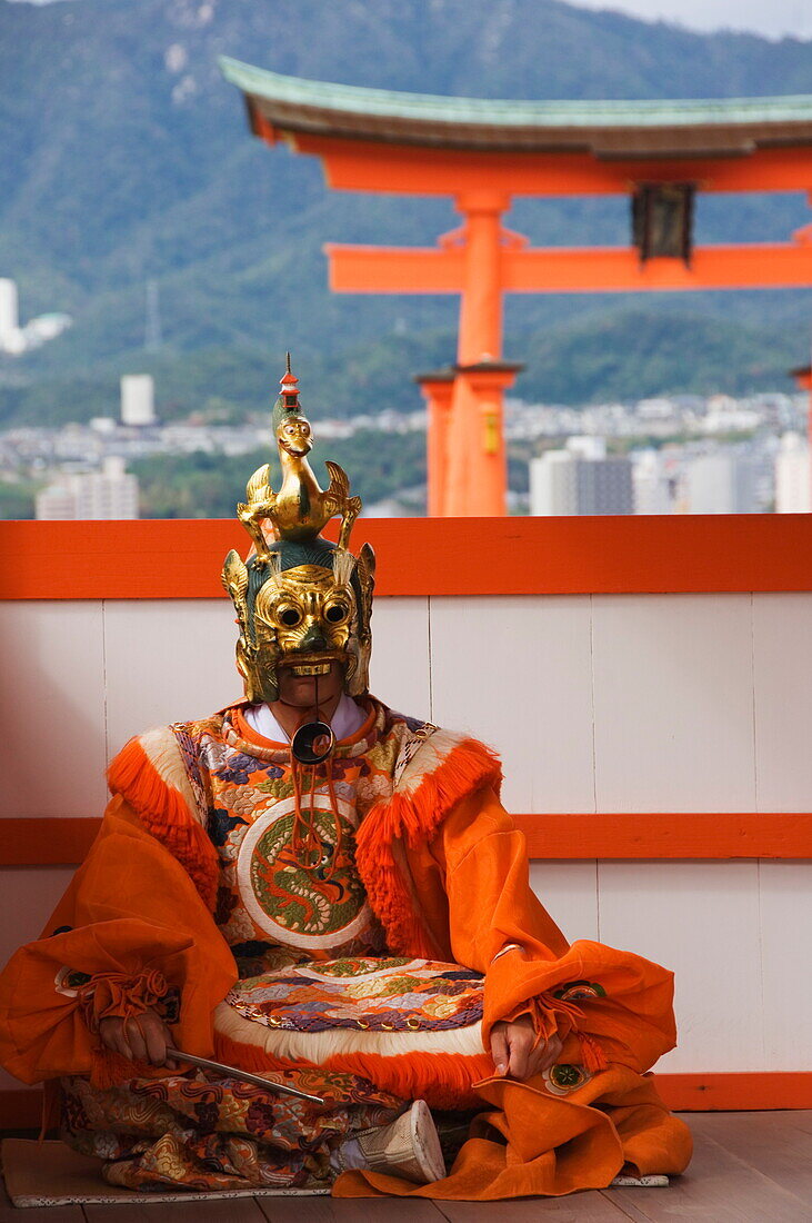 A Wedding Ceremony Dance Performer in front of the Floating Torii Gate at Itsukushima Shrine, founded in 593, UNESCO World Heritage Site, Miyajima Island, Hiroshima prefecture, Honshu Island, Japan, Asia