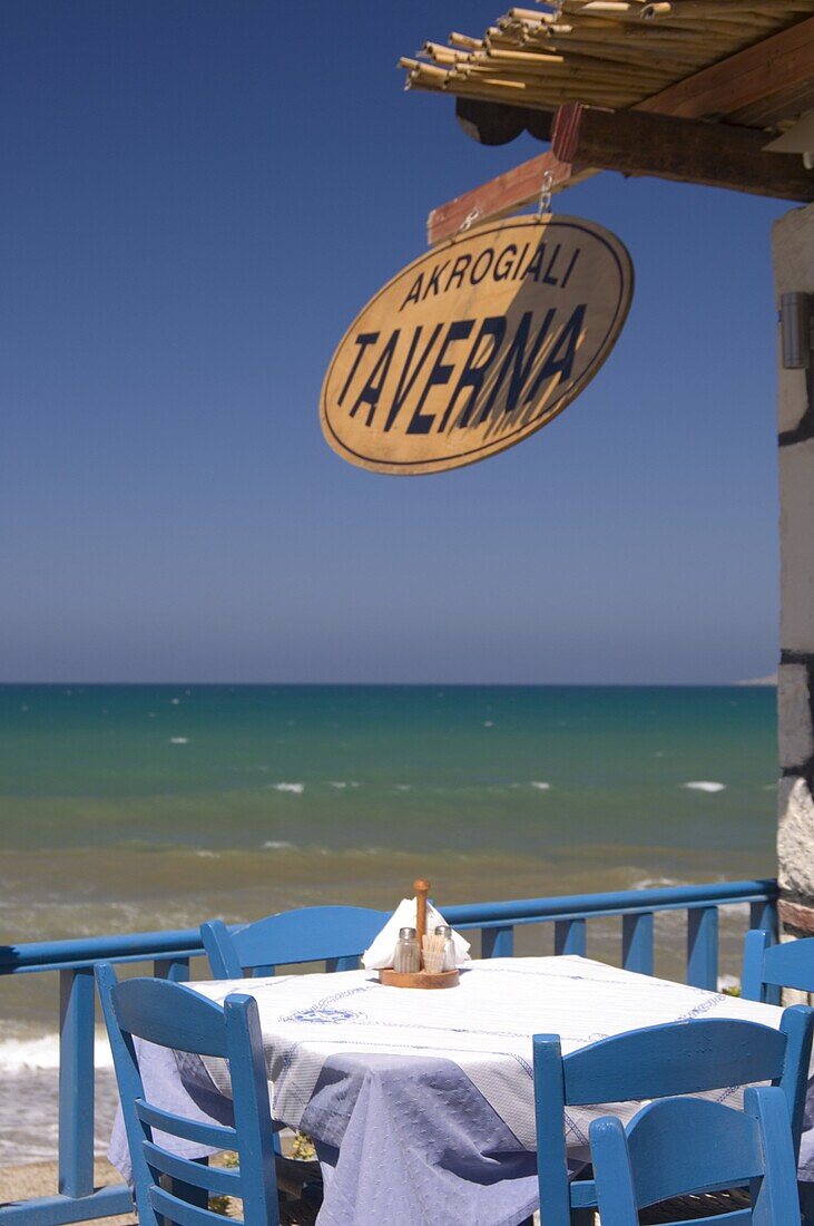 A taverna table overlooking the sea in Kalives on the North coast of Crete, Greek Islands, Greece, Europe