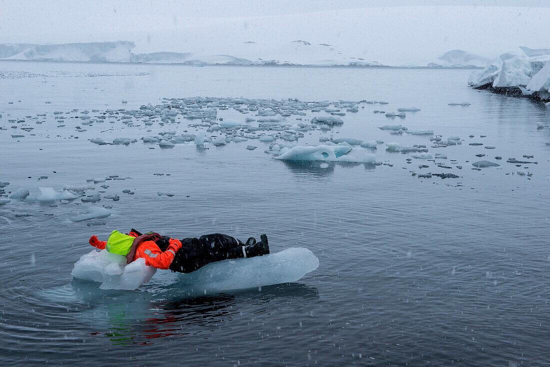 Träumen vom heimischen Sofa: Ein Crew-Mitglied von Expeditions-Kreuzfahrtschiff MS Hanseatic (Hapag-Lloyd Kreuzfahrten) chillt auf einer Eisscholle, Weddell-Meer, Antarktische Halbinsel, Antarktis