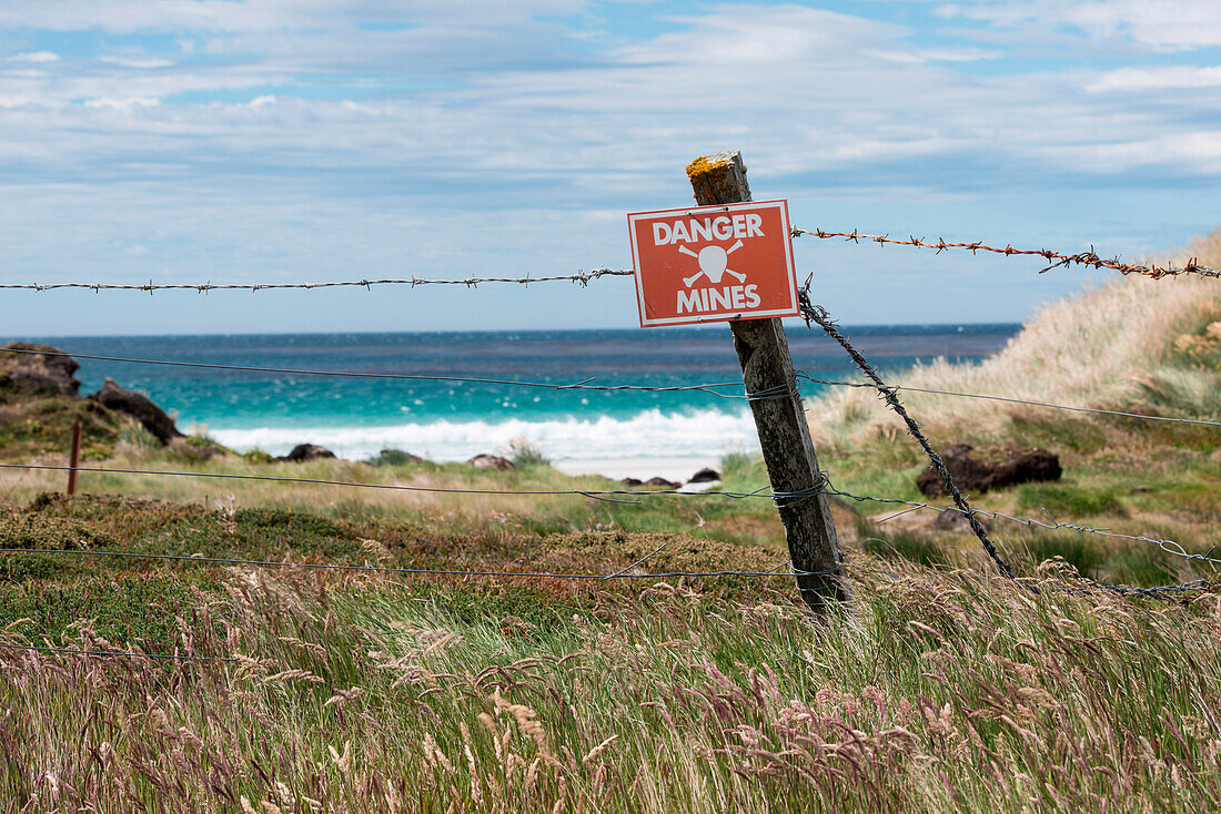 Uninviting beach with mine warning sign (large areas are still live minefields, left by the retreating Argentinian army at the end of the Falkland Islands war), Stanley, Falkland Islands, British Overseas Territory