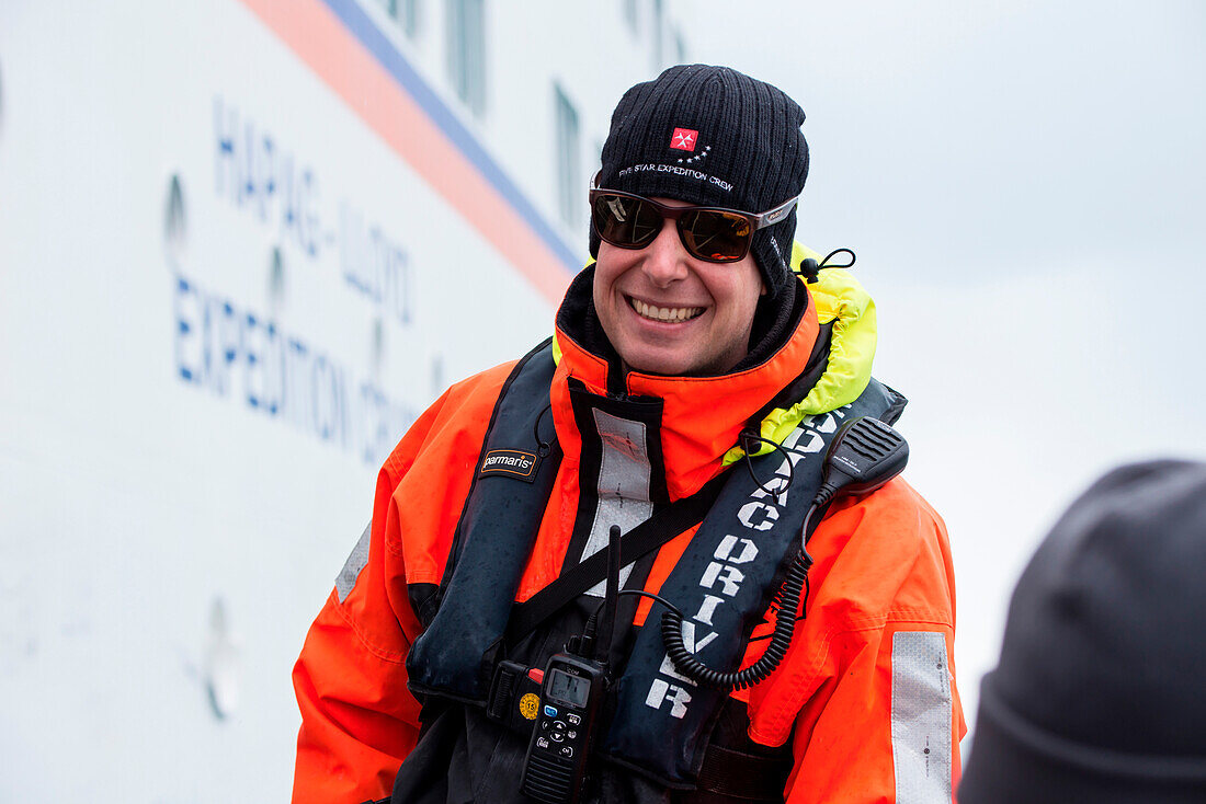 Fröhlicher Fahrer von einem Zodiac Schlauchboot von Expeditions-Kreuzfahrtschiff MS Hanseatic (Hapag-Lloyd Kreuzfahrten), St. Andrews Bay, Südgeorgien, Antarktis