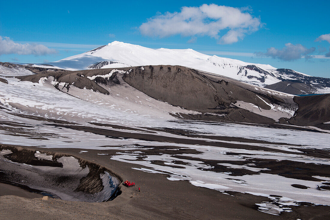 Passagiere von Expeditions-Kreuzfahrtschiff MS Hanseatic (Hapag-Lloyd Kreuzfahrten) an Kraterrand mit Blick auf majestätische Bergkulisse, Telephone Bay, Deception Island, Südshetland-Inseln, Antarktis