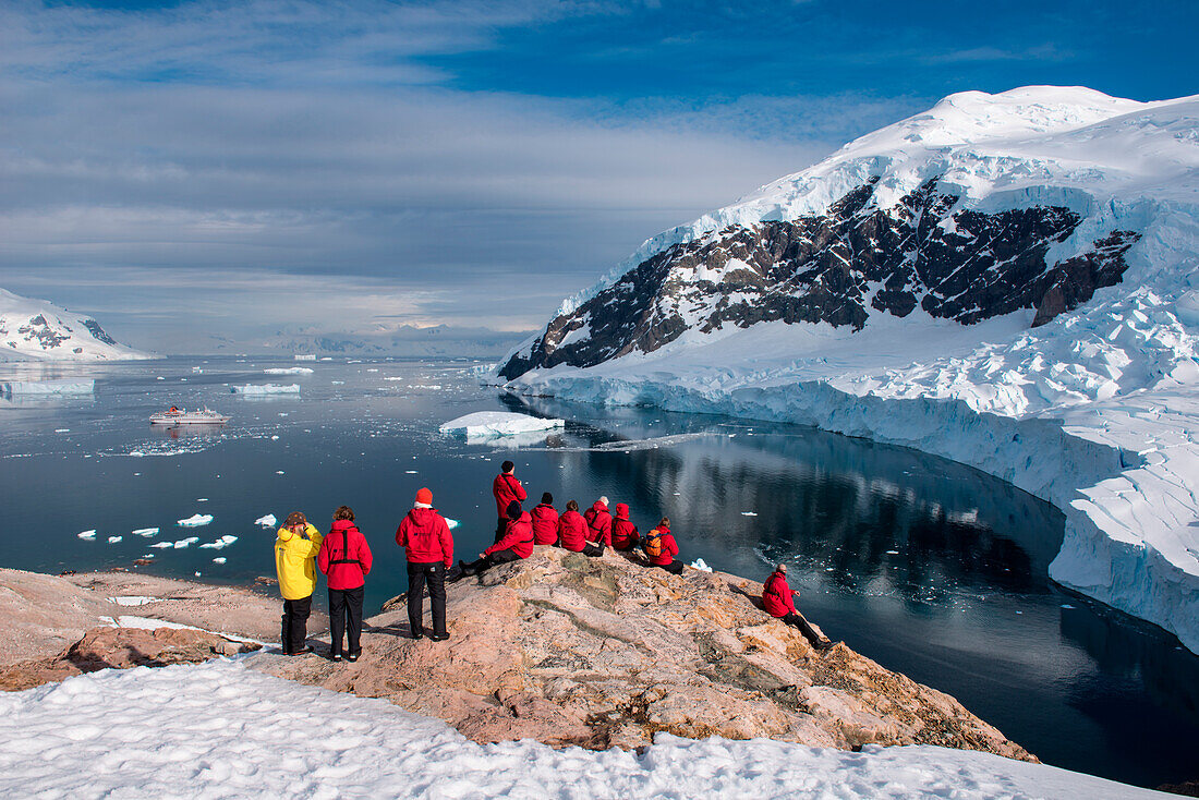 Passengers from expedition cruise ship MS Hanseatic (Hapag-Lloyd Cruises) admire view from hilltop, Neko Harbour, Graham Land, Antarctica