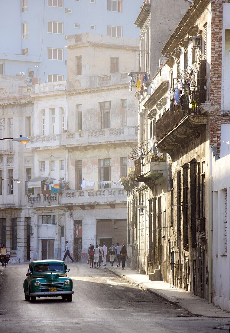 Old American car driving along quiet street in Havana Centro, Havana, Cuba, West Indies, Caribbean, Central America