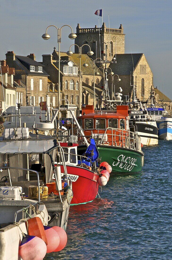 Harbour and fishing boats with houses and church in the background, Barfleur, Manche, Normandy, France, Europe