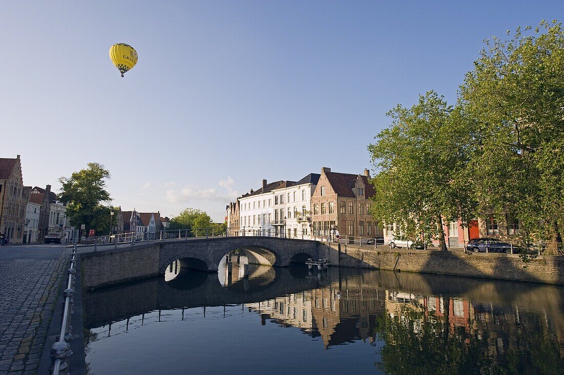 Hot air balloon floating over rooftops, houses reflected in a canal, old town, UNESCO World Heritage Site, Bruges, Flanders, Belgium, Europe