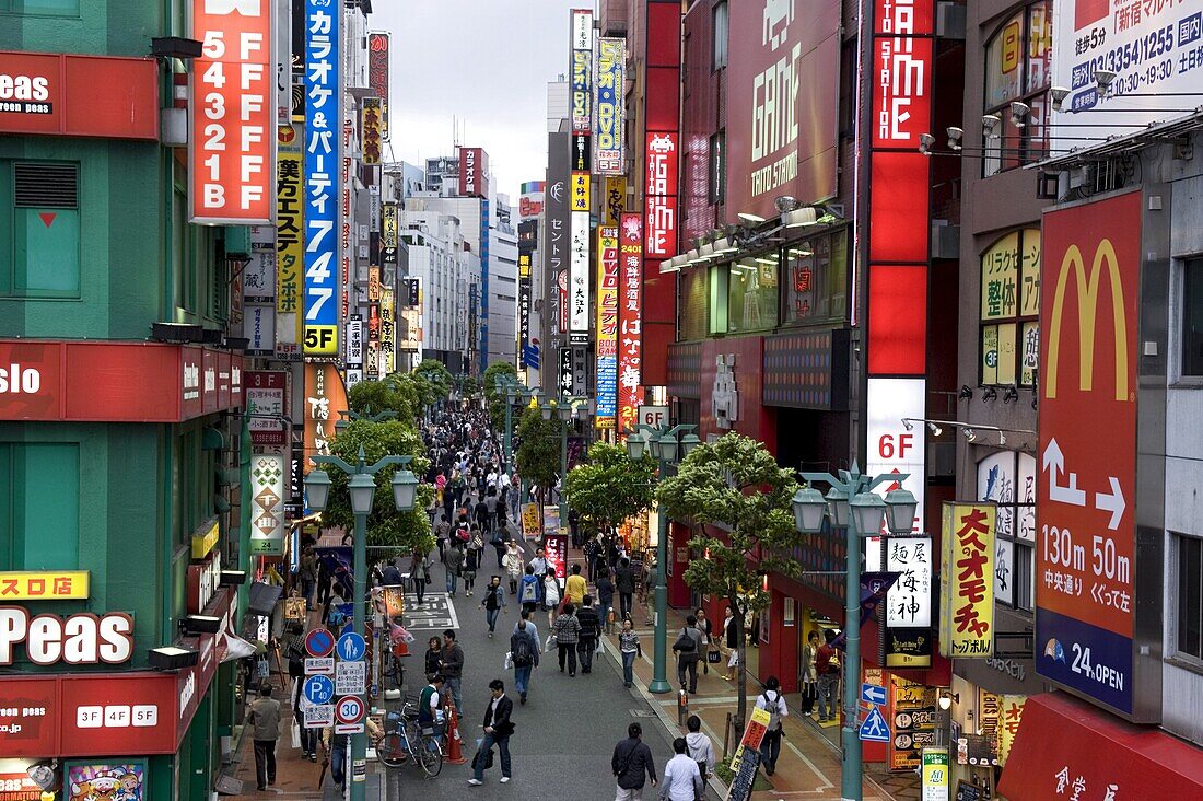 A pedestrian street lined with shops and signboards attracts a crowd in Shinjuku, Tokyo, Japan, Asia