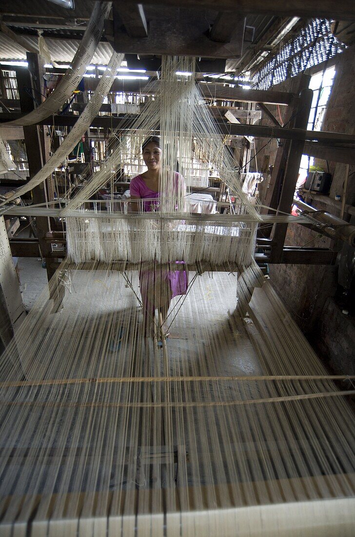 Woman at village silk loom weaving Assam Muga natural undyed silk in Sualkuchi, Assam, India, Asia