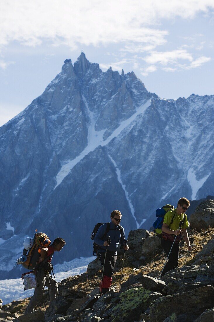 Hikers on Mont Blanc against mountain backdrop of Aiguille du Midi, Chamonix, France, Europe