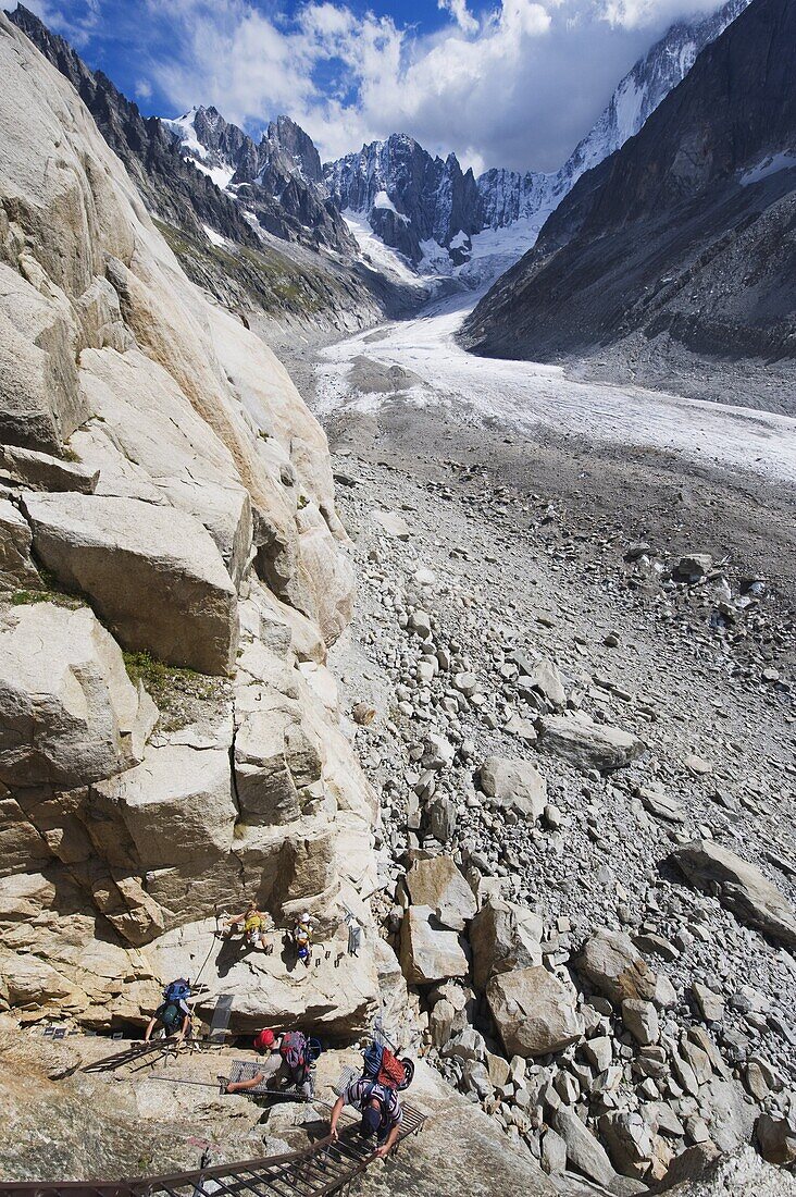 Climbers on a ladder on a rock face above Mer de Glace, Mont Blanc range, Chamonix, French Alps, France, Europe