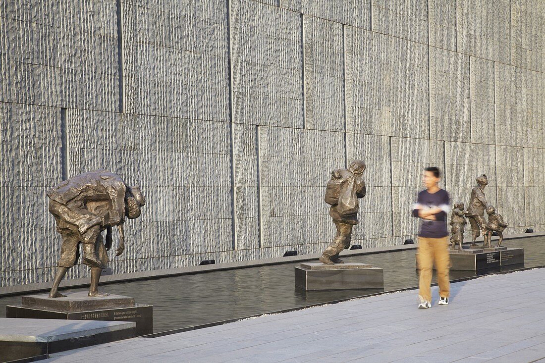 Man walking past statues at Memorial for the Nanjing Massacre, Nanjing, Jiangsu, China, Asia